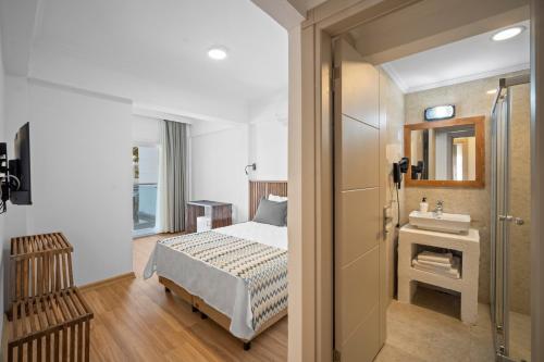 a bathroom with a bed and a sink in a room at Costa Viva Bodrum in Bodrum City