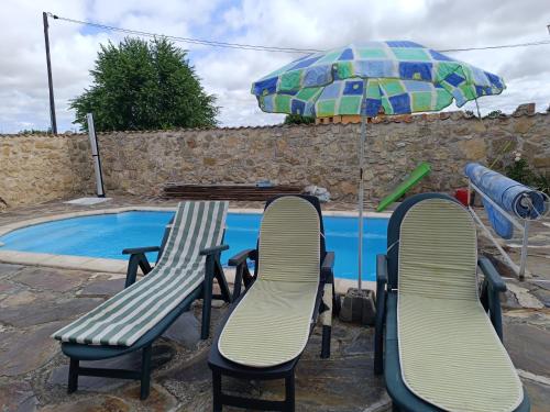 Mata de Quintanar的住宿－El Refugio de la Esquina，游泳池旁的桌椅和遮阳伞