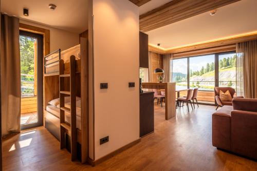 a room with a bunk bed and a dining room at Alpin Peaks in Turracher Hohe