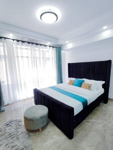 a bedroom with a large bed with a large window at Heartland Gardens Apartments Kilimani Nairobi in Nairobi