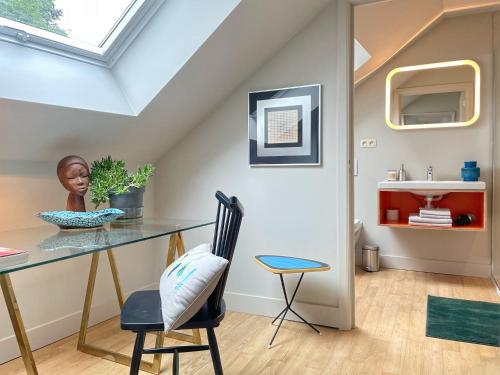 a room with a table and a chair and a sink at L'Art de la fugue in Daverdisse