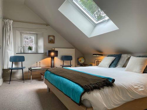 a bedroom with a large bed and a skylight at L'Art de la fugue in Daverdisse