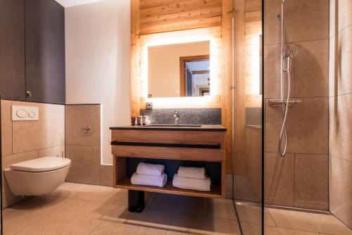 a bathroom with a sink and a toilet and a mirror at Alpin Peaks in Turracher Hohe