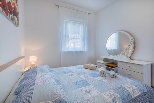 um quarto com uma cama com um espelho e uma cómoda em Apartments Tatjana II em Cres