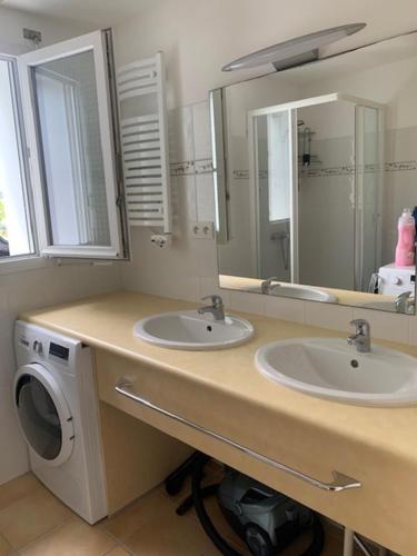 a bathroom with two sinks and a washing machine at Maison 400m de la plage in Crozon