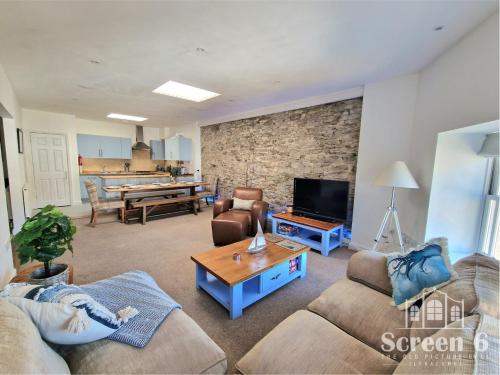 Una sala de estar con dos sofás y un televisor. en 4 bedroom 'Screen6' by Tunnels Beaches in a historic building, en Ilfracombe