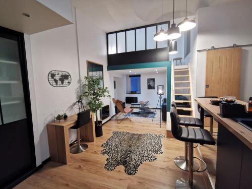 a kitchen and living room with a table and chairs at Tout confort proche transport - Au Coin du Château in Nantes