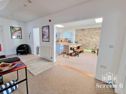 una sala de estar abierta con una pared de piedra y una mesa. en 4 bedroom 'Screen6' by Tunnels Beaches in a historic building, en Ilfracombe