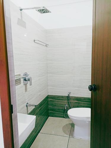 a bathroom with a toilet and a tub and a sink at THEKKUMPURAM RESIDENCY in Kondotti