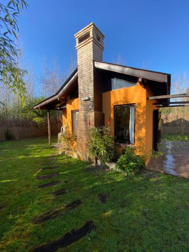 una casa en un patio con césped en El Quincho en Costa del Este