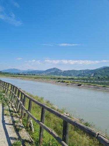 une clôture à côté d'une rivière avec des montagnes en arrière-plan dans l'établissement Chambre d'Hôtes, à Volonne