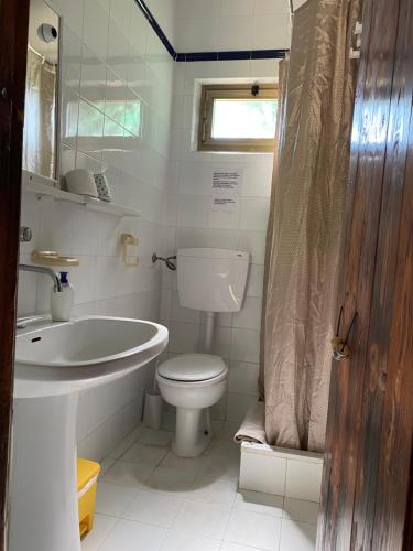 a bathroom with a toilet and a tub and a sink at Villaggio La Roccia camping in Lampedusa