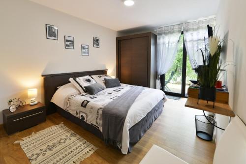 sypialnia z dużym łóżkiem i dużym oknem w obiekcie Chambres et Table d'hotes du calvaire w mieście Villefranche-de-Rouergue