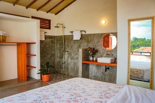 a bedroom with a bed and a bathroom with a mirror at Casa Peak Barichara in Barichara