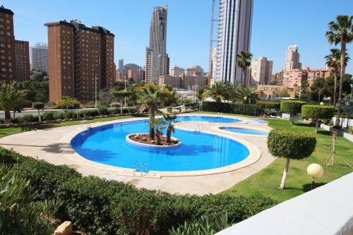 a large swimming pool with a city skyline in the background at Las Marinas, apartamento muy amplio cerca de la playa in Benidorm