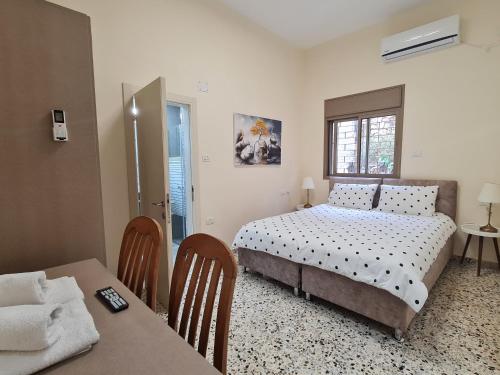 a bedroom with a bed and a table and chairs at Rizik's Guest House in Nazareth
