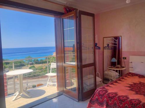 a bedroom with a view of the ocean from a balcony at Stars Home in Tropea