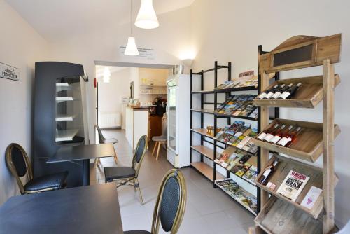 a coffee shop with tables and chairs and a shelf with wine bottles at Chambres et Table d'hotes du calvaire in Villefranche-de-Rouergue