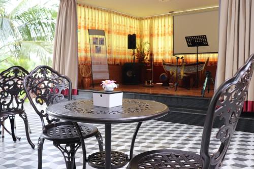 a table and chairs in a room with a stage at Toek Chha Temple Resort in Kampong Cham