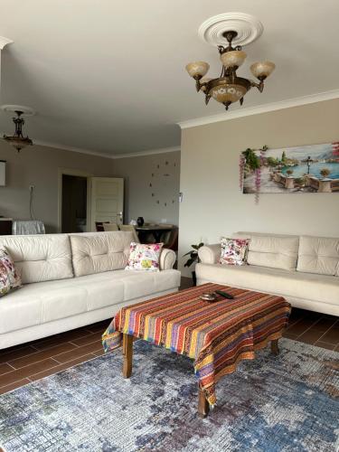 a living room with two white couches and a table at Zeytinlik Suits in Akcaabat
