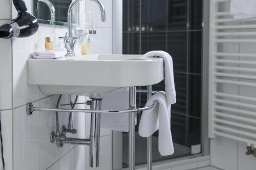 a white sink in a bathroom with a shower at Hotel Zum Alten Brunnen in Rheine