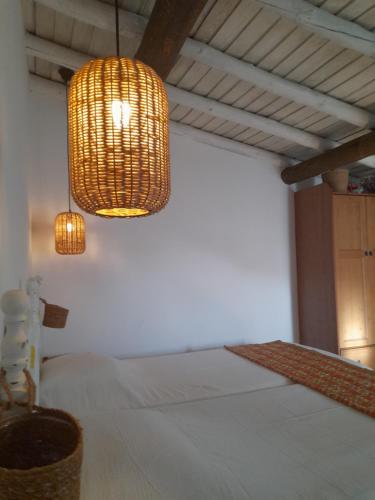 a bedroom with a bed and a hanging light at Olive -Casa da Boavista in Alegrete