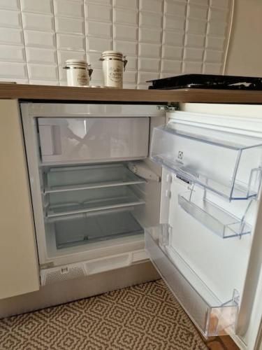 an empty refrigerator with its door open in a kitchen at Casa Myrtifolia in Todi