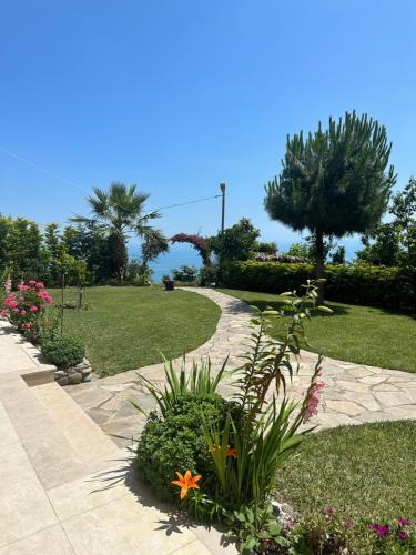 a garden with flowers and a walk way at Zeytinlik Suits in Akcaabat