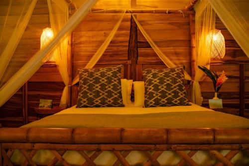 a bedroom with a bed in a log cabin at Salvia Madre Hotel Boutique in Guachaca