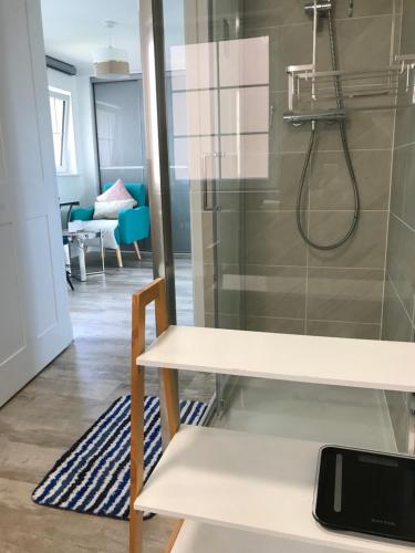 Cette chambre comprend une table blanche et une douche. dans l'établissement large en suite bedroom for 1-4 persons No breakfast provided, à Édimbourg