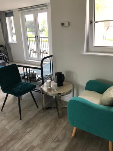 uma sala de estar com um sofá, uma mesa e uma cadeira em large en suite bedroom for 1-4 persons No breakfast provided em Edimburgo