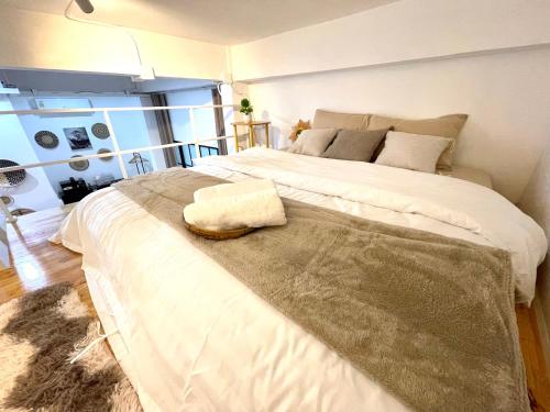 a bedroom with a large white bed with a rug on it at Relax in town,Grand Palace in Bangkok