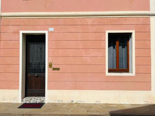 um edifício cor-de-rosa com duas janelas e uma porta em CENTRAL HOUSE em Piove di Sacco