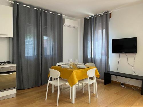 uma sala de jantar com uma mesa amarela e cadeiras em CENTRAL HOUSE em Piove di Sacco