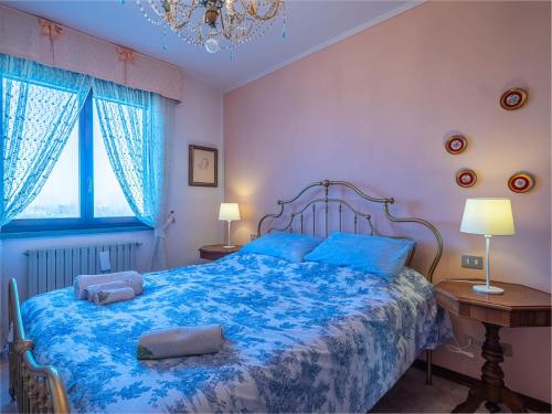 una camera con un letto blu con due cuscini sopra di Il Bosco di RE guesthouse, camera matrimoniale a Reggio Emilia