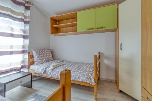 a small bedroom with a bed and a cabinet at Mara in Umag