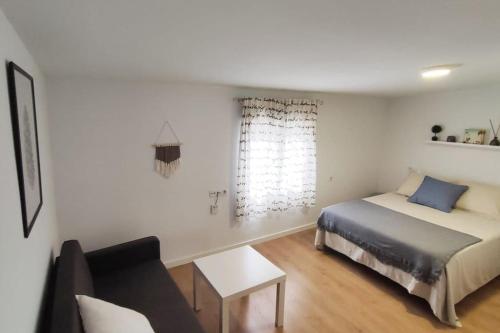 a bedroom with a bed and a couch at La Casa de los Tiles in Vélez Blanco