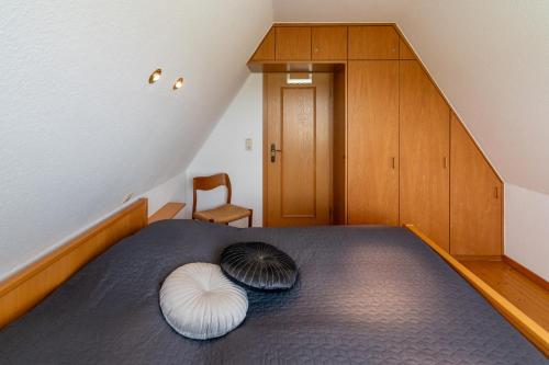 um quarto com uma cama com duas almofadas brancas em Spatzenhorst em Dornumersiel
