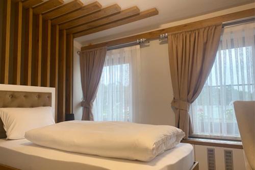 a bedroom with a bed with a large window at Spreehotel Spremberg in Spremberg