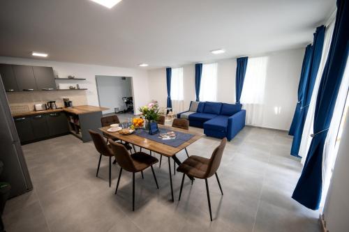 a living room with a table and a blue couch at Tótündér Vendégház in Levelek