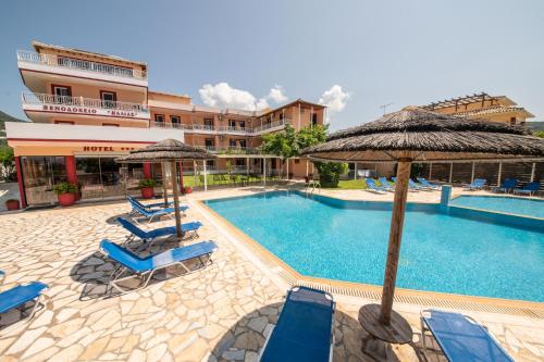 a swimming pool with chairs and umbrellas next to a hotel at Kalias Hotel in Vasiliki