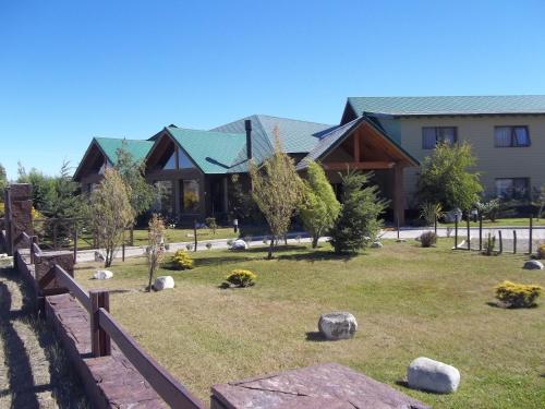 a house with a yard with rocks and trees at Konke Calafate Hotel in El Calafate