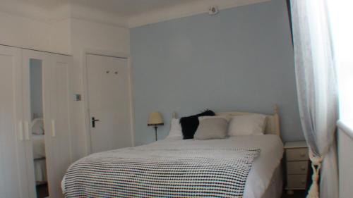 a white bedroom with a bed with white pillows at Vernon Lodge Flat 2 in Bournemouth