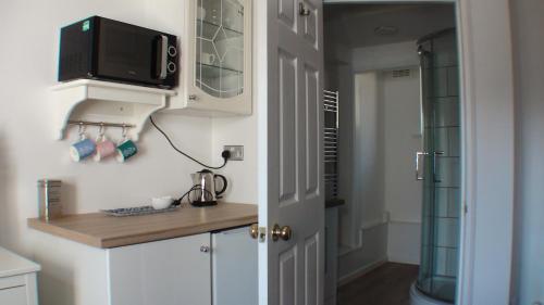 uma cozinha com um balcão com uma televisão na parede em Vernon Lodge Flat 2 em Bournemouth
