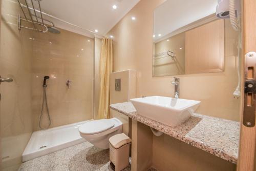uma casa de banho com um lavatório, um WC e um chuveiro em Kalias Hotel em Vasiliki