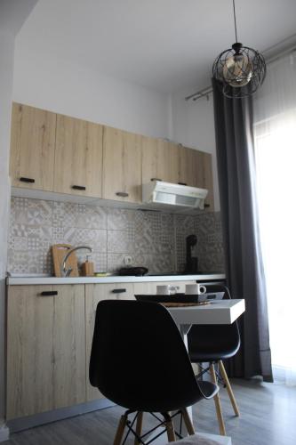 een keuken met houten kasten, een wastafel en 2 stoelen bij StuDio 57(10) in Néa Khilí