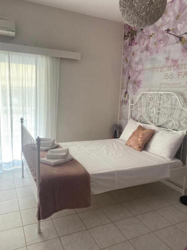 1 dormitorio con 1 cama grande y pared de flores en Seaside pearl, en Ligia