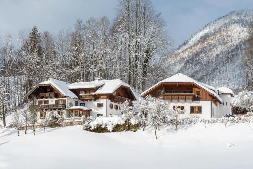 a house covered in snow in the mountains at Gästehaus Kasbichler in St. Wolfgang