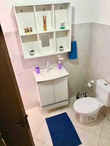 a bathroom with a white toilet and a sink at Flat Mirante in Pipa