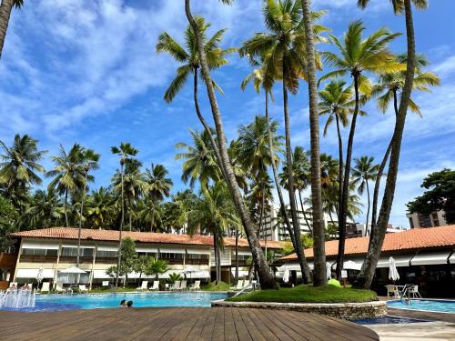 un complejo con palmeras y piscina en Jatiuca Suítes Resort FLAT en Maceió